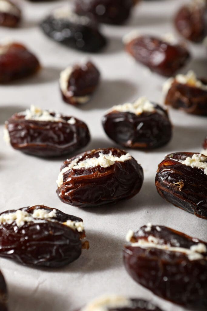 Stuffed dates on a parchment-lined sheet pan before baking