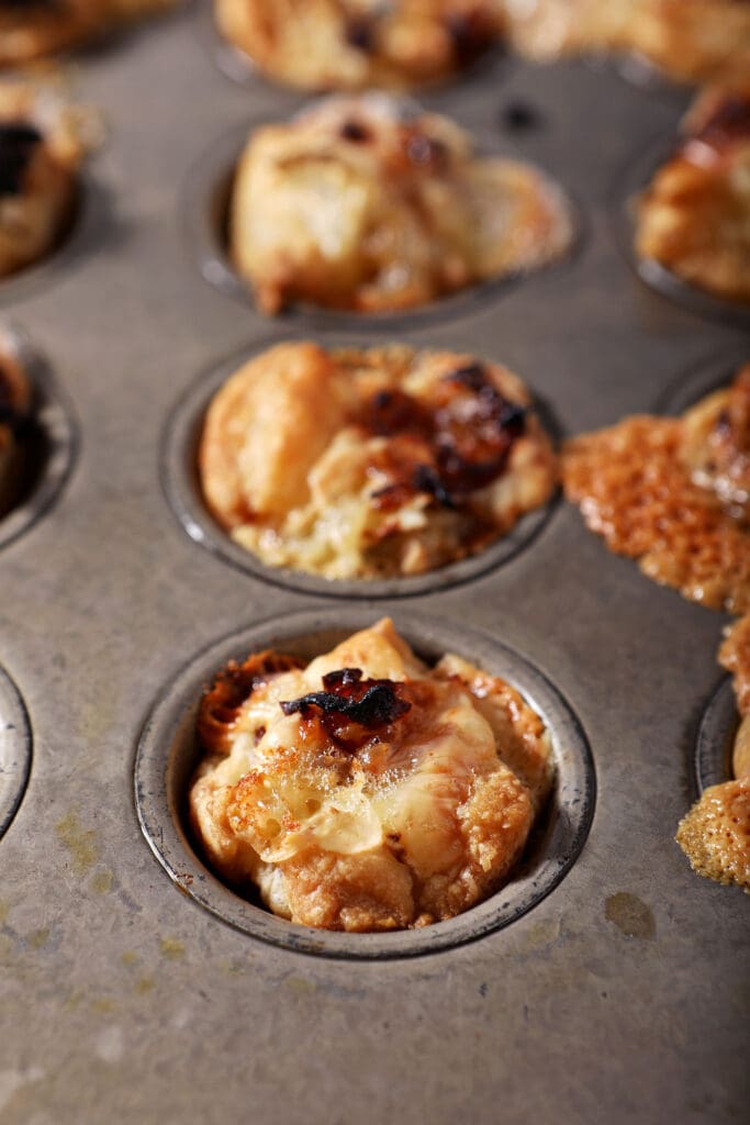 Caramelized onion baked brie bites in a mini muffin tin after baking