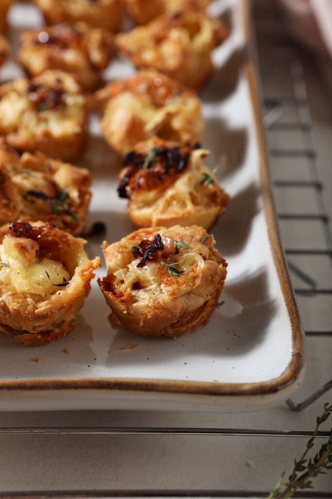 Baked brie bites on a white serving platter