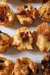 Close up of baked brie bites on a white platter from above