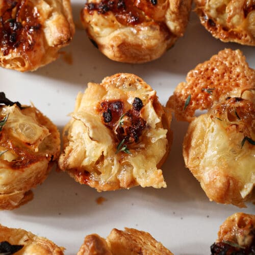 Close up of baked brie bites on a white platter from above