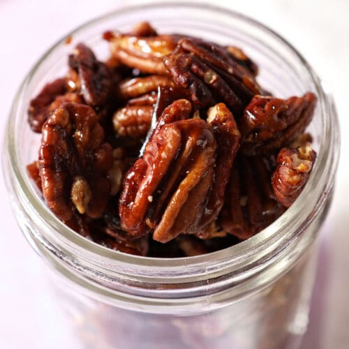 Close up of glazed pecans in a mason jar