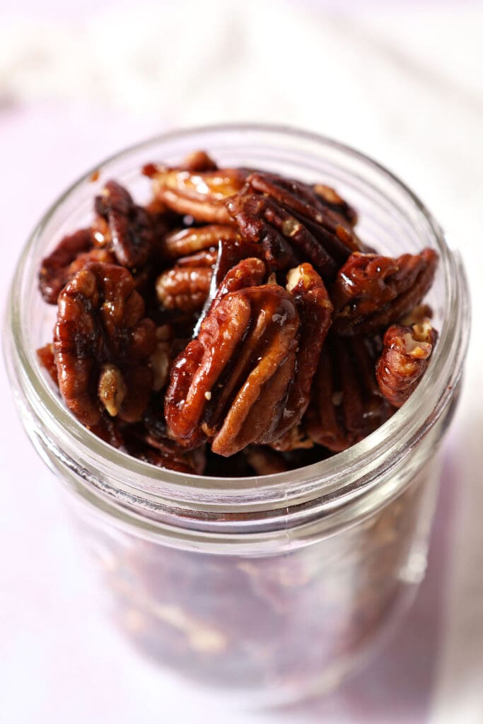 Close up of glazed pecans in a mason jar