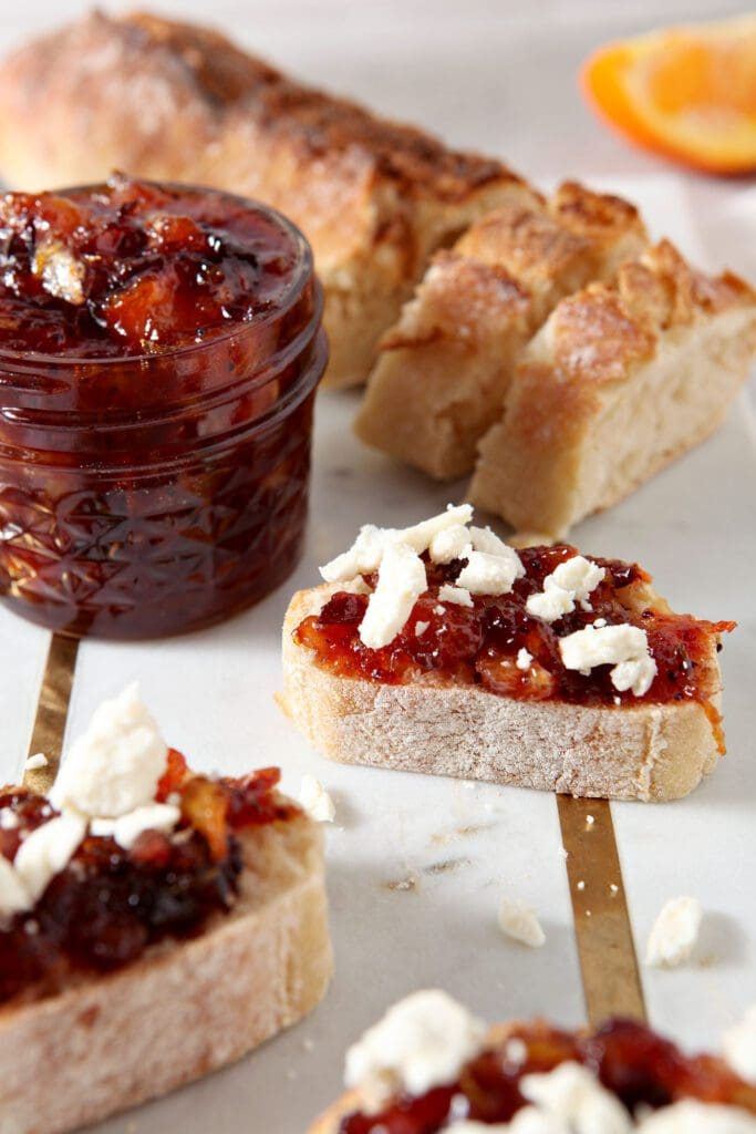 Close up of bruschetta with cranberry compote on top of it and feta crumbles