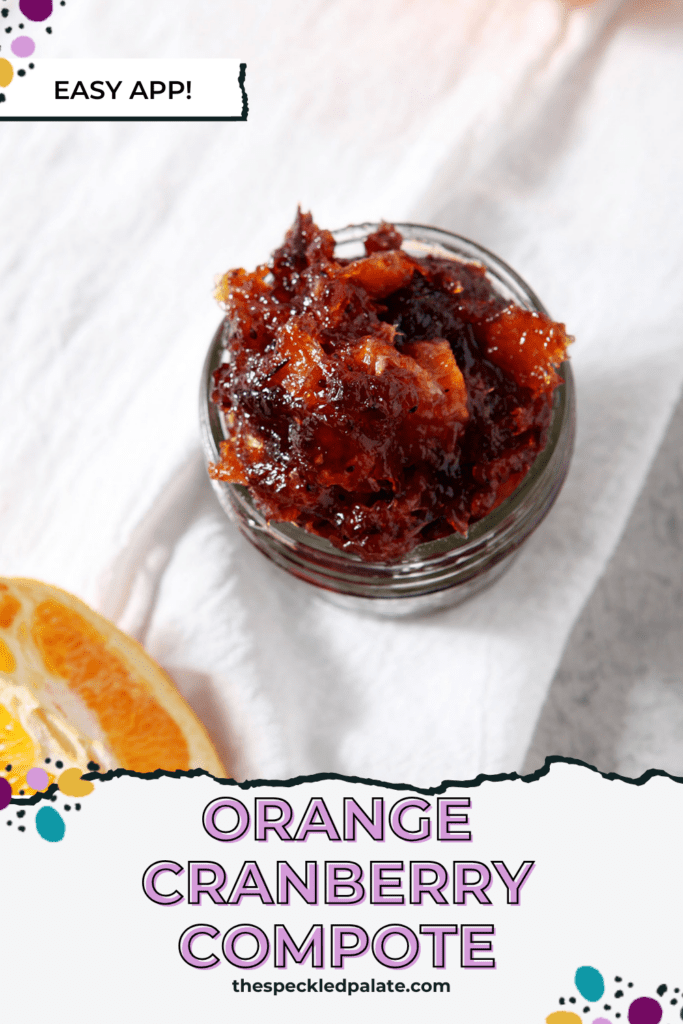 A jar of cranberry compote on a white linen towel next to orange slices with the text orange cranberry compote