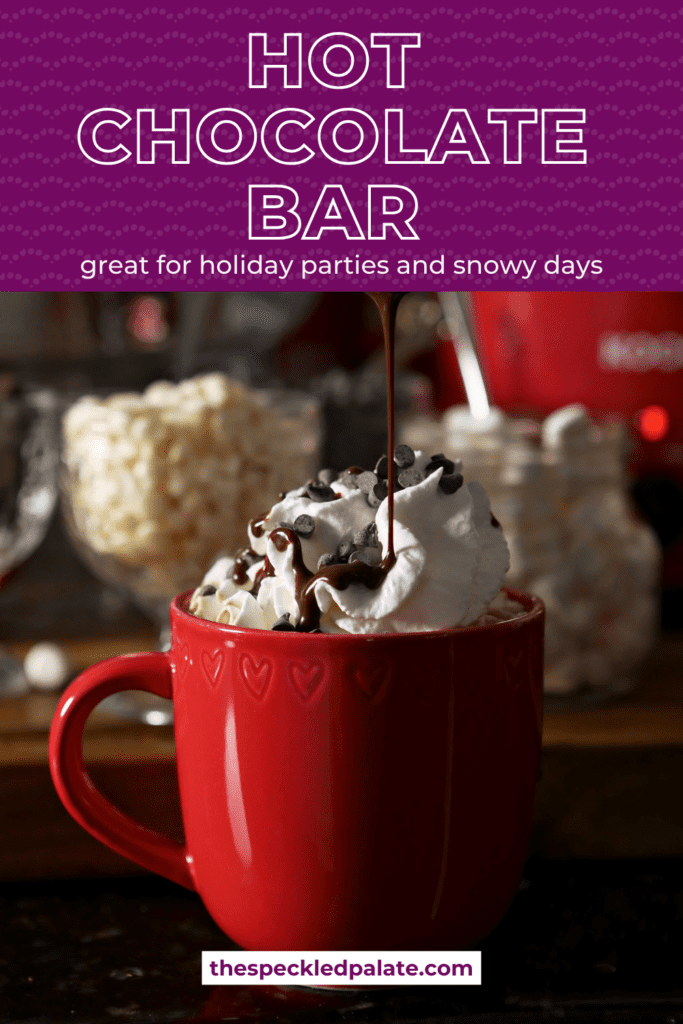 Chocolate syrup pours on top of a red mug of cocoa topped with whipped cream with the text hot chocolate bar great for holiday parties and snowy days