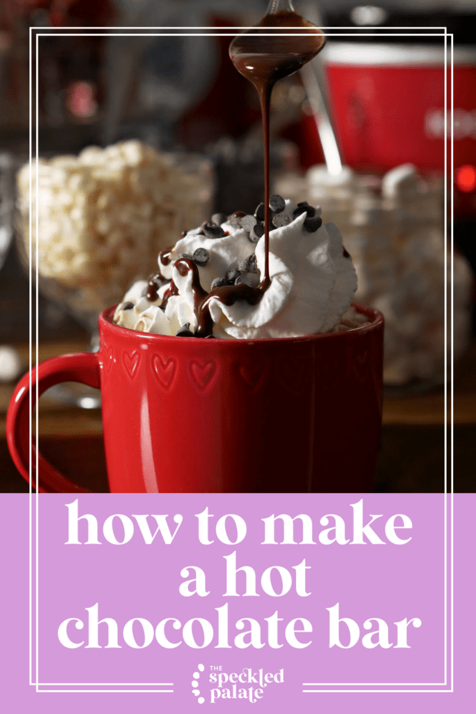 Chocolate syrup pours on top of a red mug of cocoa topped with whipped cream with the text how to make a hot chocolate bar