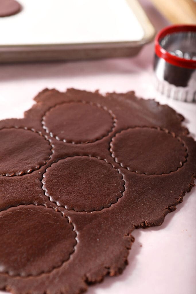 Cut out chocolate sugar cookies on a pink surface