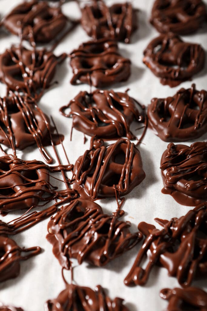 Chocolate Covered Pretzels drizzled with extra chocolate to create texture cooling on parchment