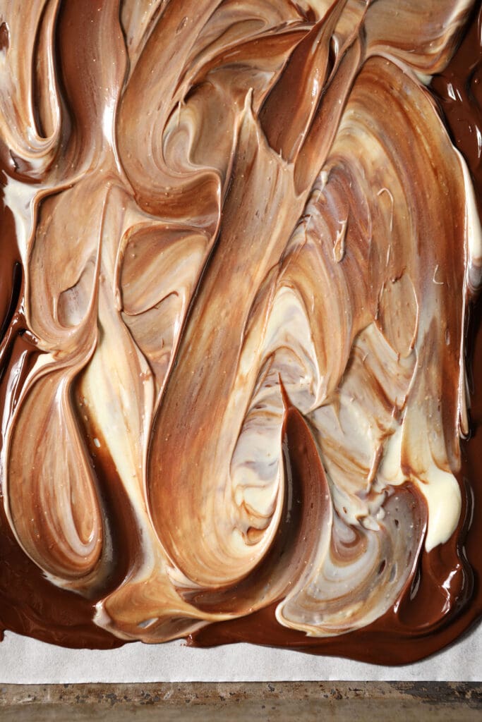 Swirled white and dark chocolate on a sheet pan