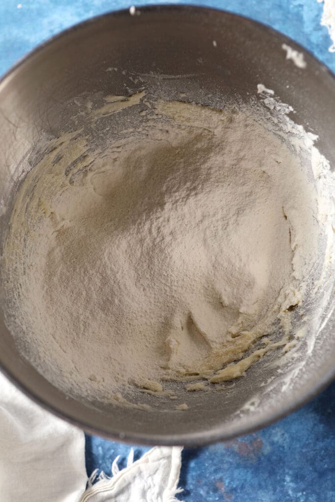 Sifted flour and salt on top of creamed butter and sugar in a metal bowl