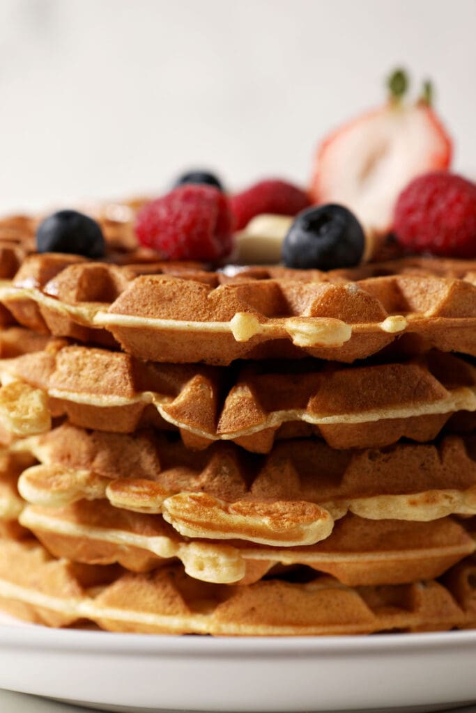 Close up of a stack of waffles topped with berries