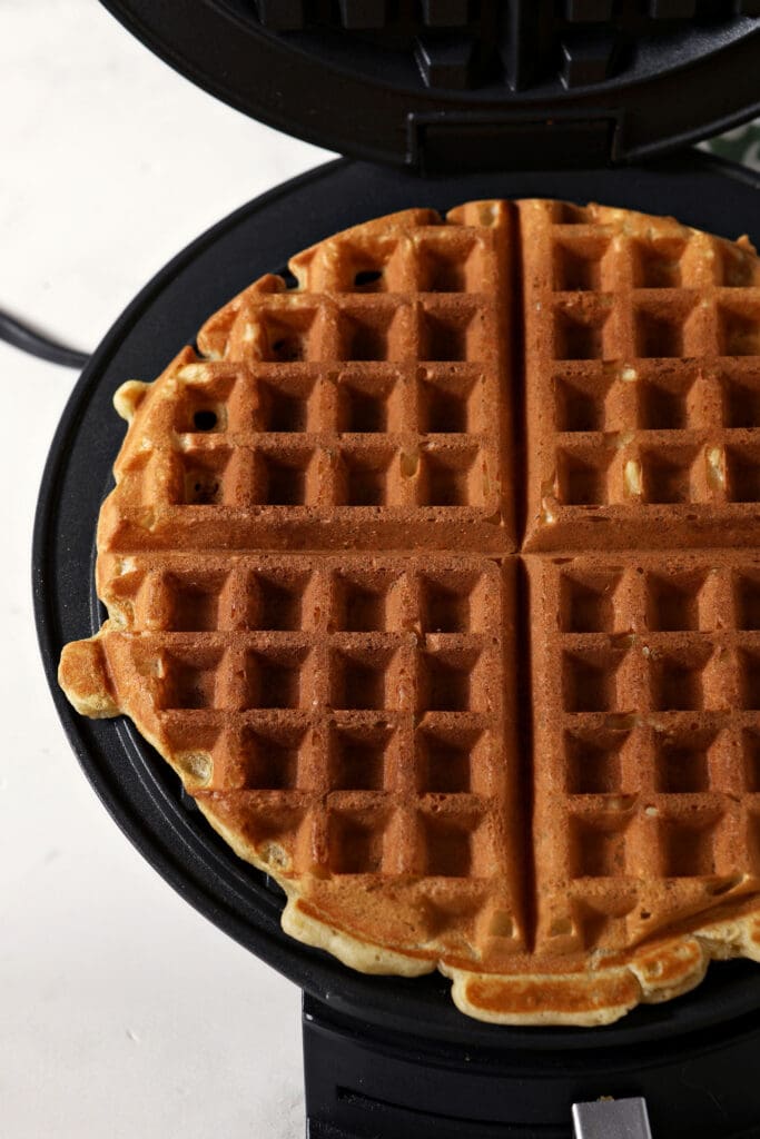 A cooked waffle in a waffle iron