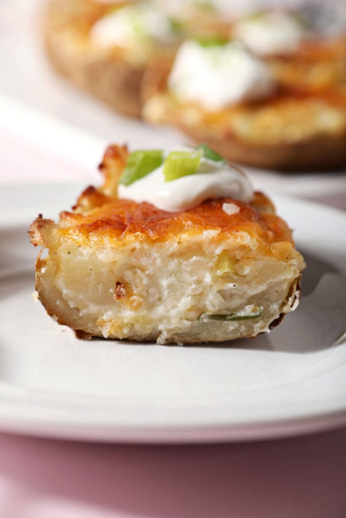 Close up of a twice baked potato on a white plate