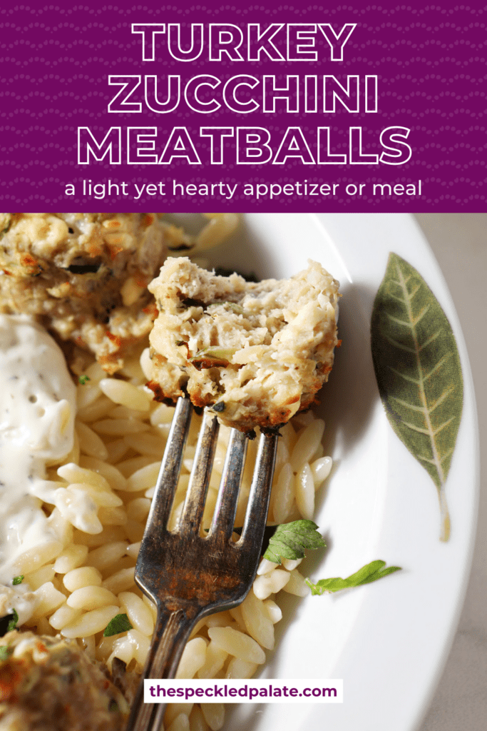 A bitten-into zucchini meatball on a fork dips into a dollop of tzatziki in orzo pasta with the text turkey zucchini meatballs a light yet hearty appetizer or meal