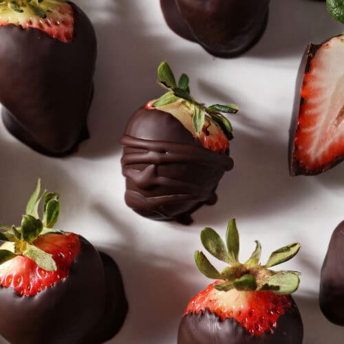 Chocolate dipped strawberries on a white platter from above