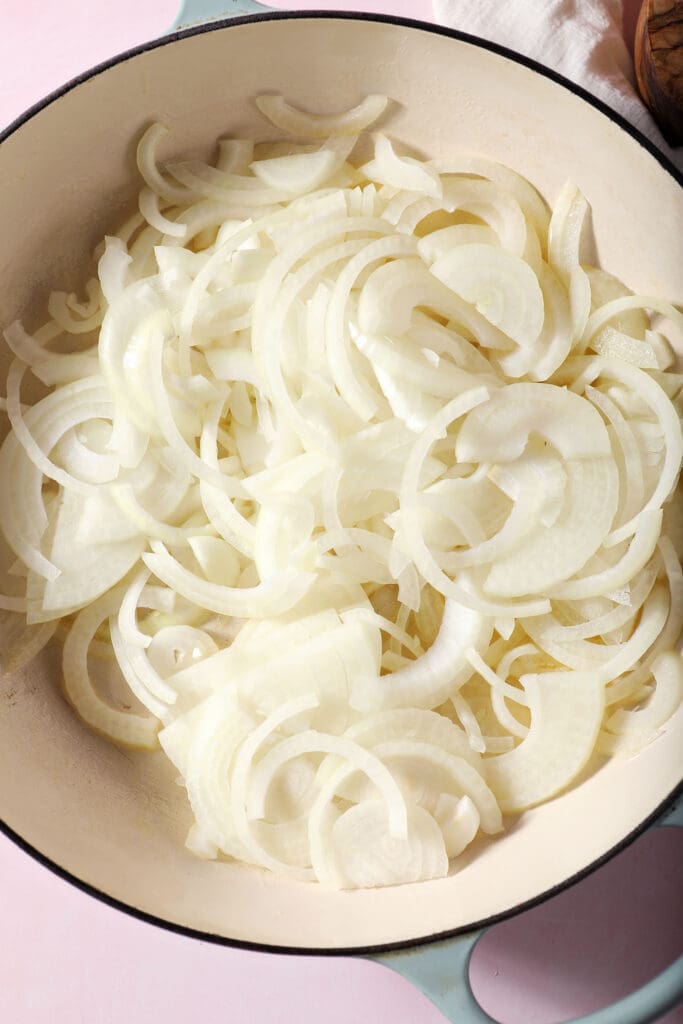 Sliced onions in a white braised pan