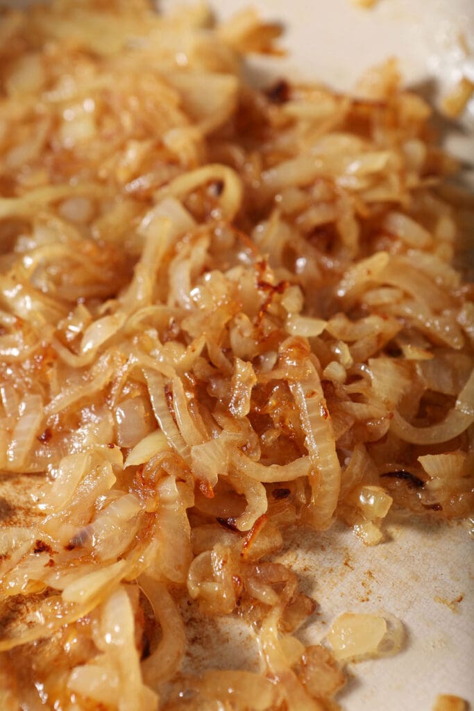 Sliced lightly caramelized onions in a skillet