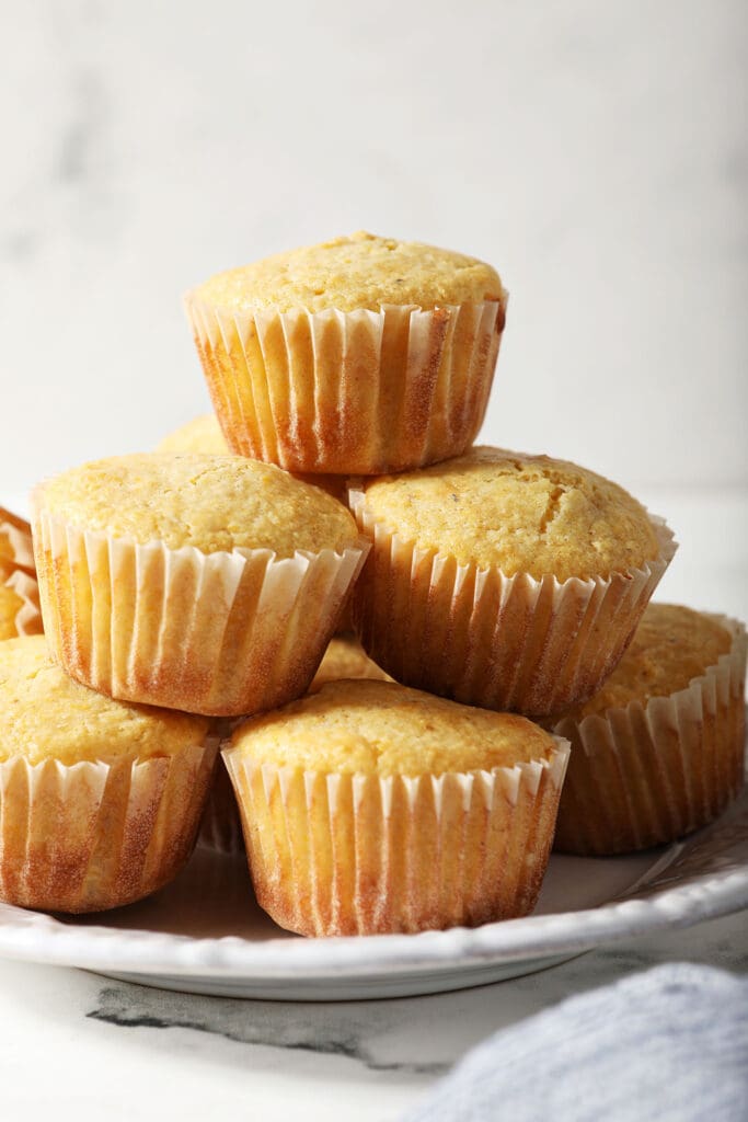 A stack of cornbread muffins on top of a white plate