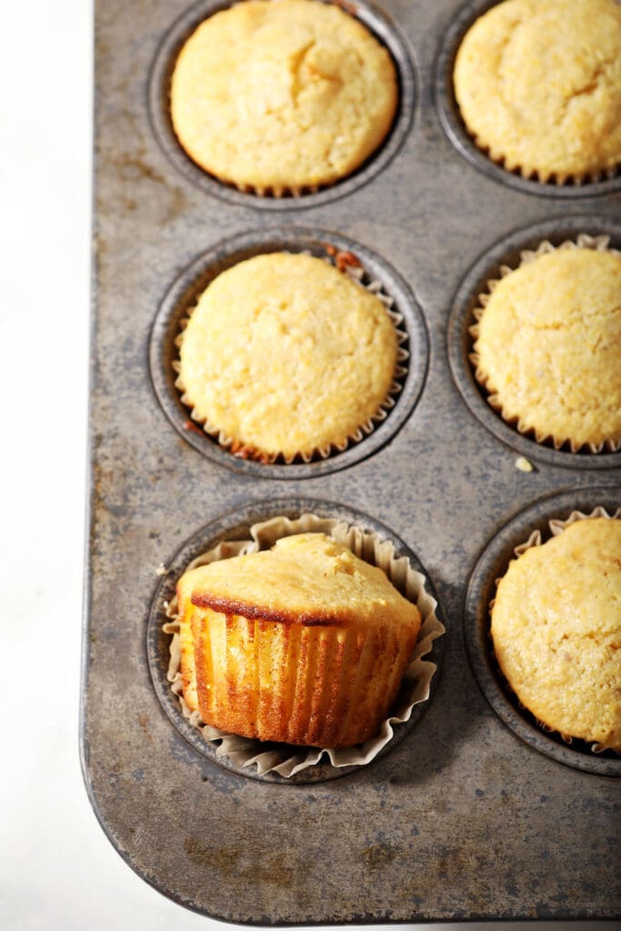 Sweet cornbread muffins in a muffin tin after baking