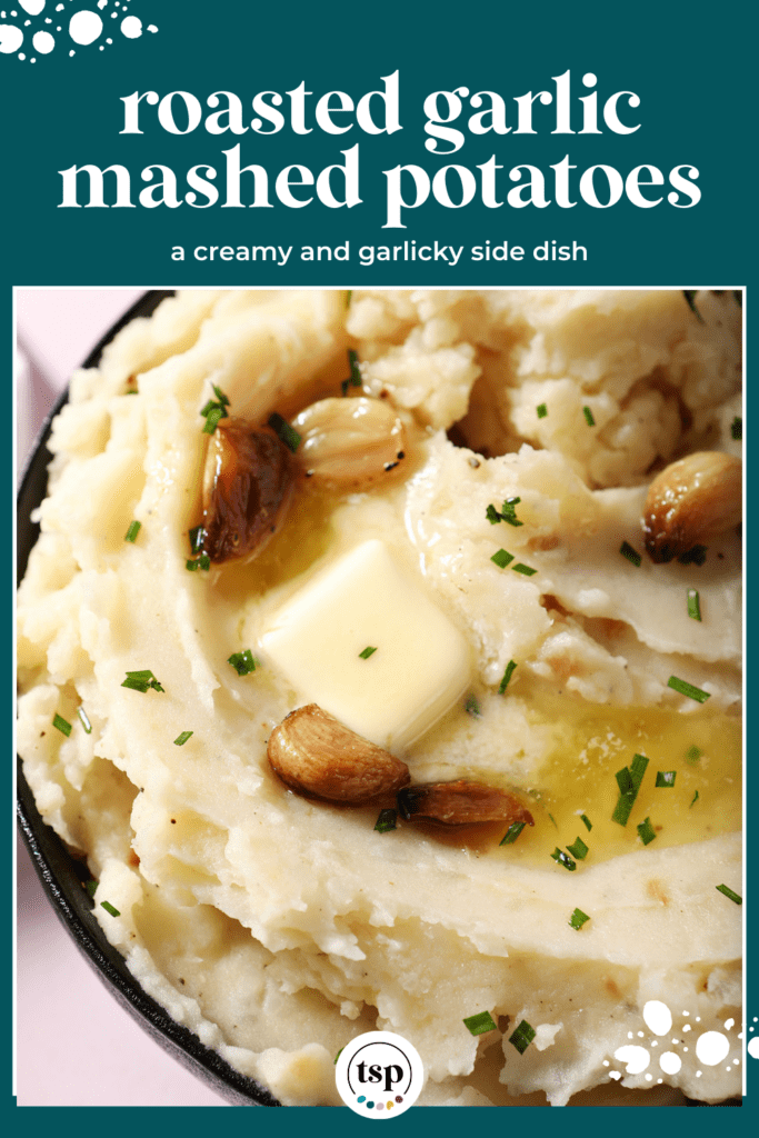 close up overhead of a bowl of roasted garlic mashed potatoes topped with melted butter and roasted garlic cloves with the text roasted garlic mashed potatoes a creamy and garlicky side dish