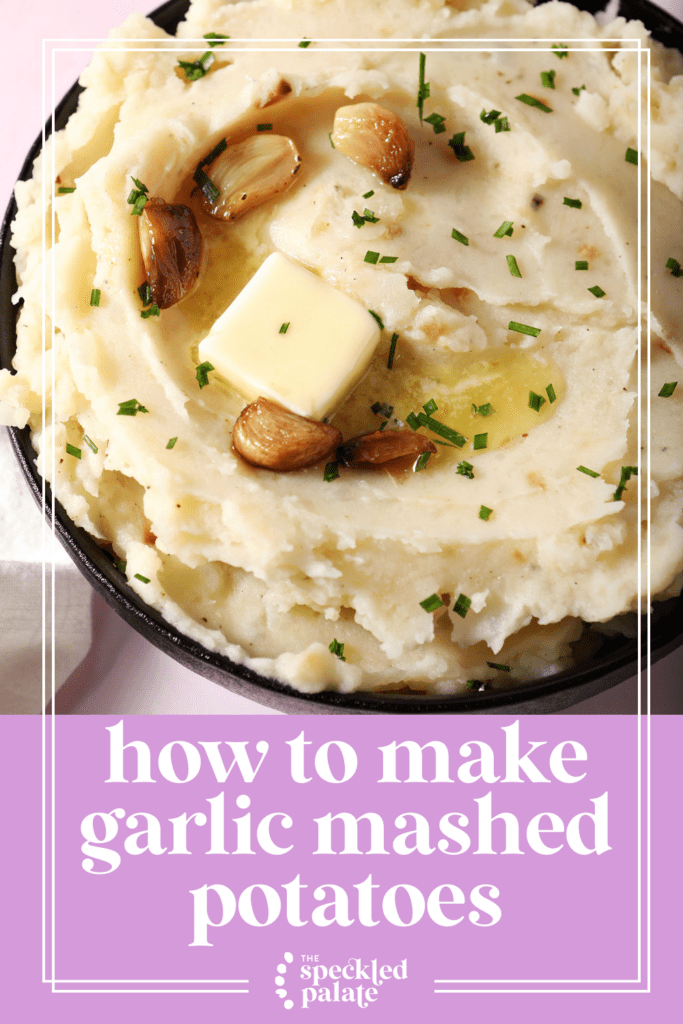 close up overhead of a bowl of roasted garlic mashed potatoes topped with melted butter and roasted garlic cloves with the text how to make roasted garlic mashed potatoes