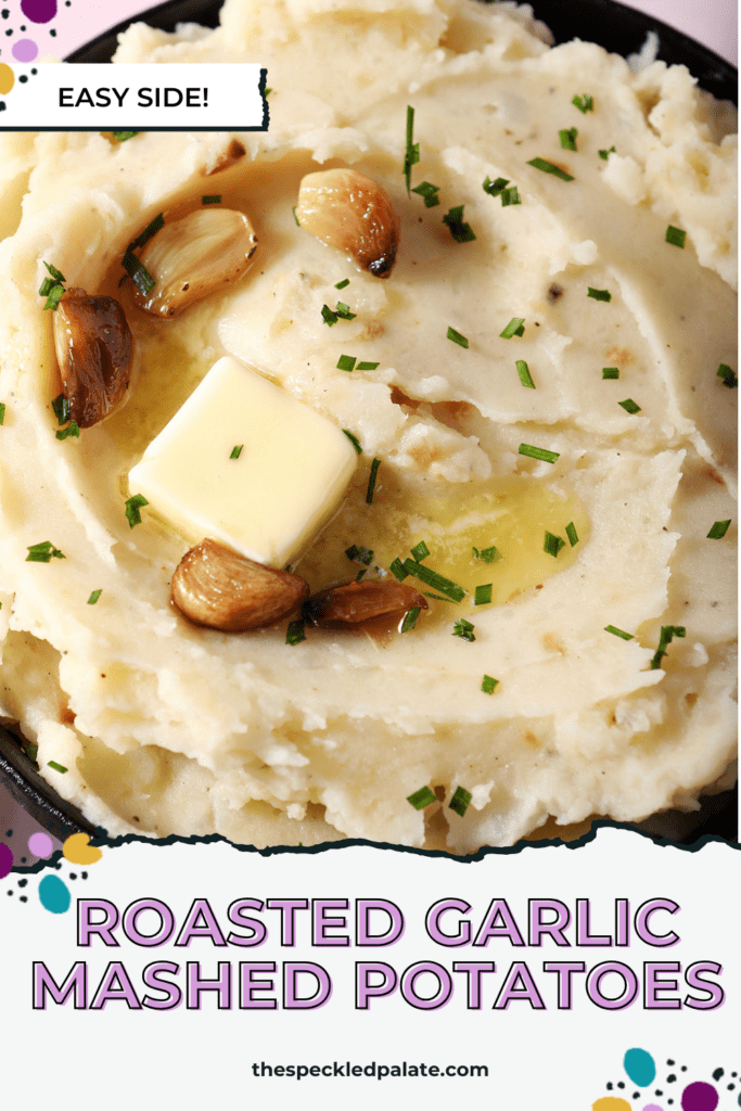 close up overhead of a bowl of roasted garlic mashed potatoes topped with melted butter and roasted garlic cloves with the text roasted garlic mashed potatoes