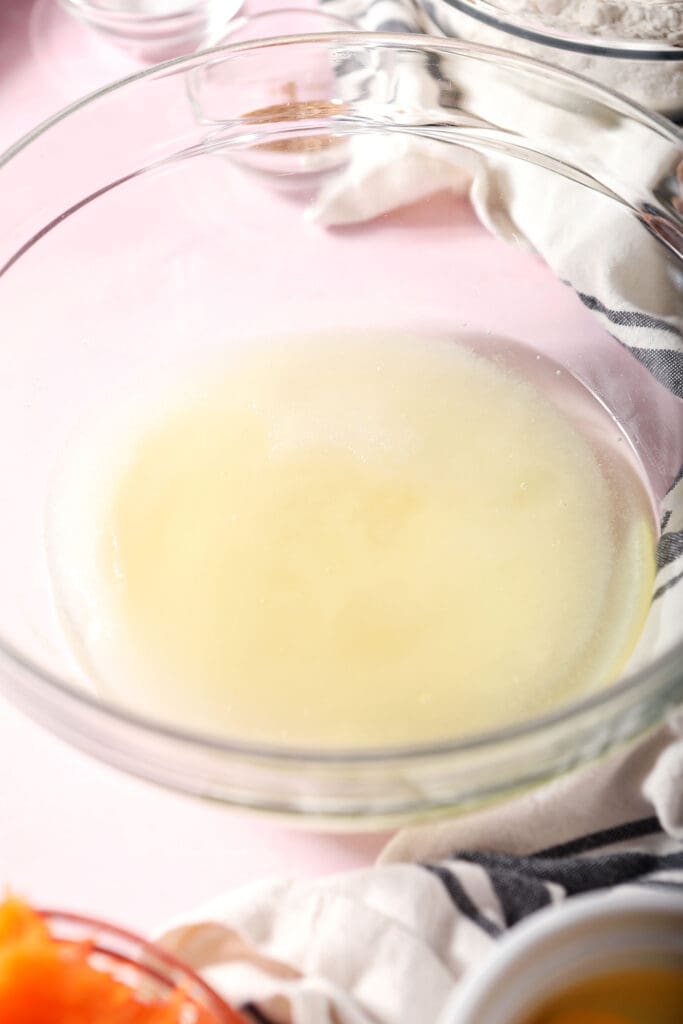 Sugar and oil in a bowl on a pink surface