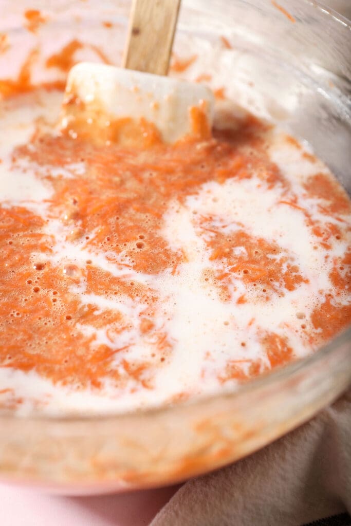 Close up of milk swirled into cake batter with a rubber spatula