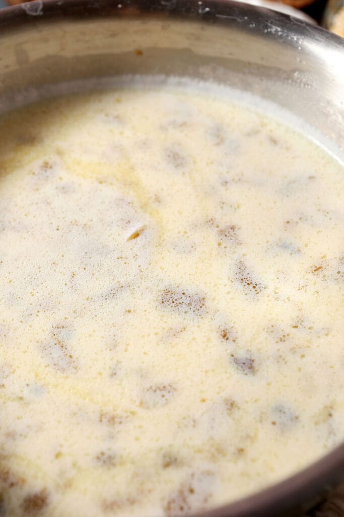 liquids added to the saucepan with roasted peppers for grits