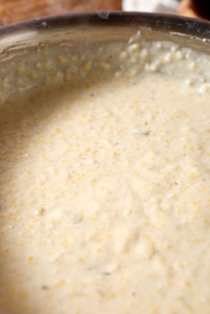 close up of cheesy grits in a skillet