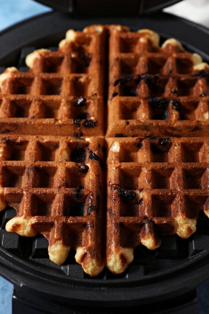 a chocolate chip waffle in a waffle iron after cooking