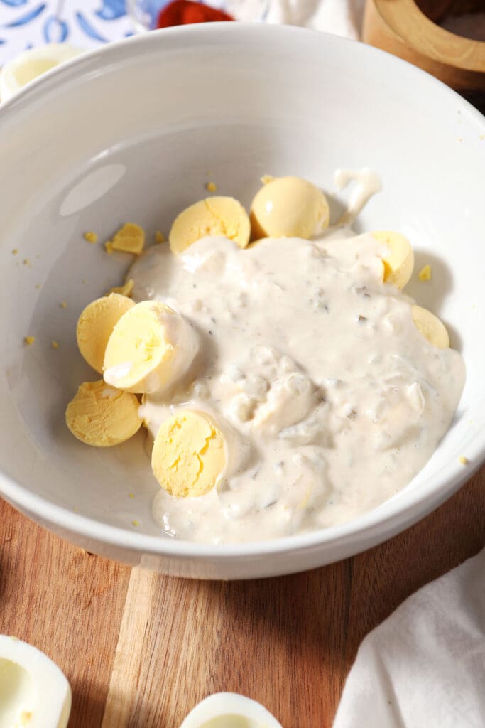 Deviled egg filling ingredients before mixing in a white bowl