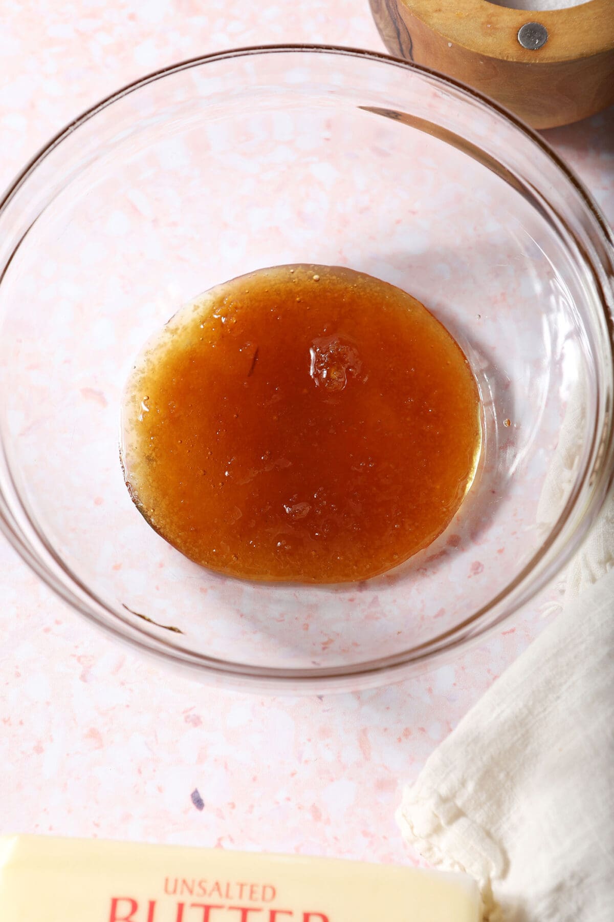 A bowl of honey on a pink surface