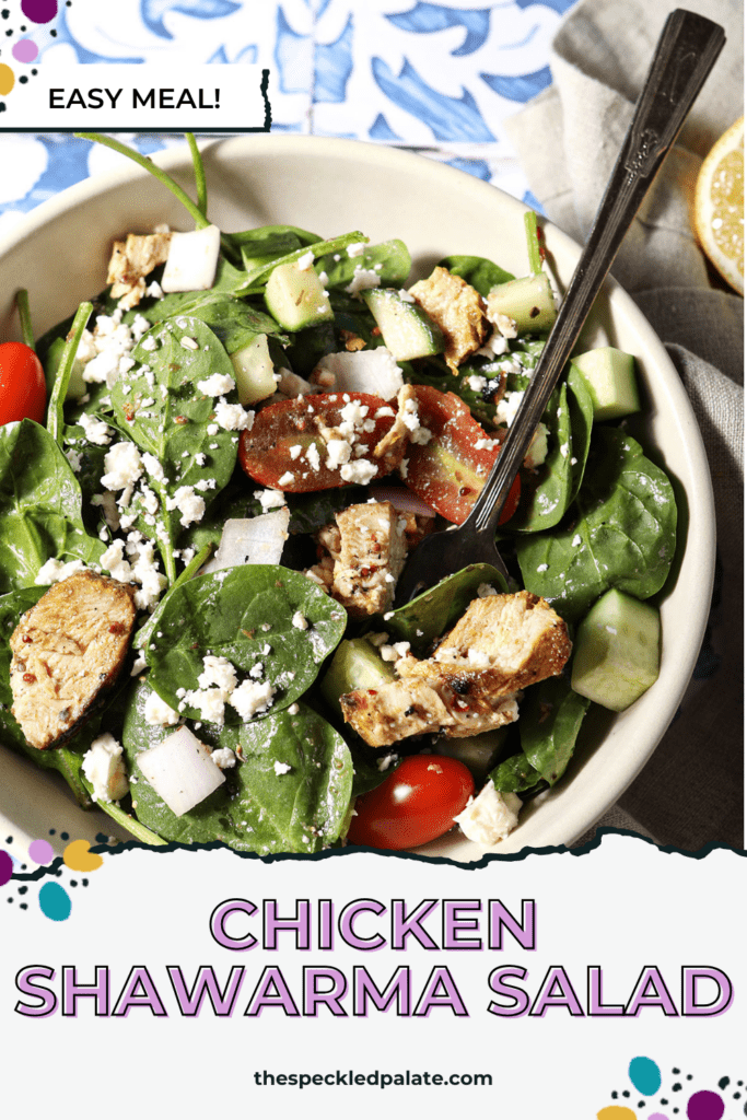 Overhead of a large bowl of shawarma chicken salad on a blue and white tiled surface with the text chicken shawarma salad