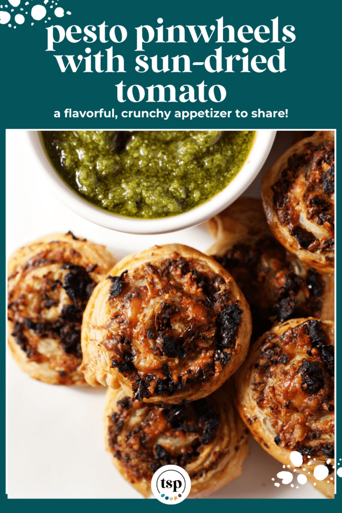 Close up of pesto pinwheels on a platter next to a container of pesto with the text pesto pinwheels with sun-dried tomato a flavorful, crunchy appetizer to share