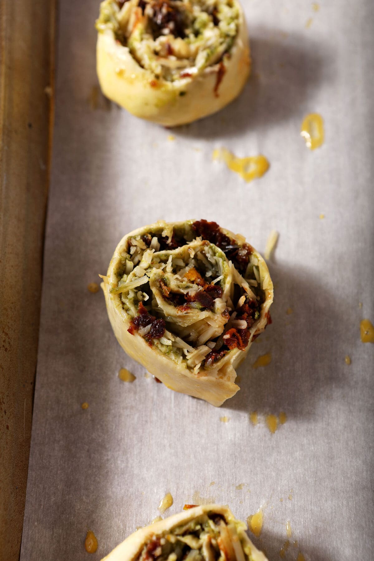 Pesto pinwheels on a sheet pan before baking
