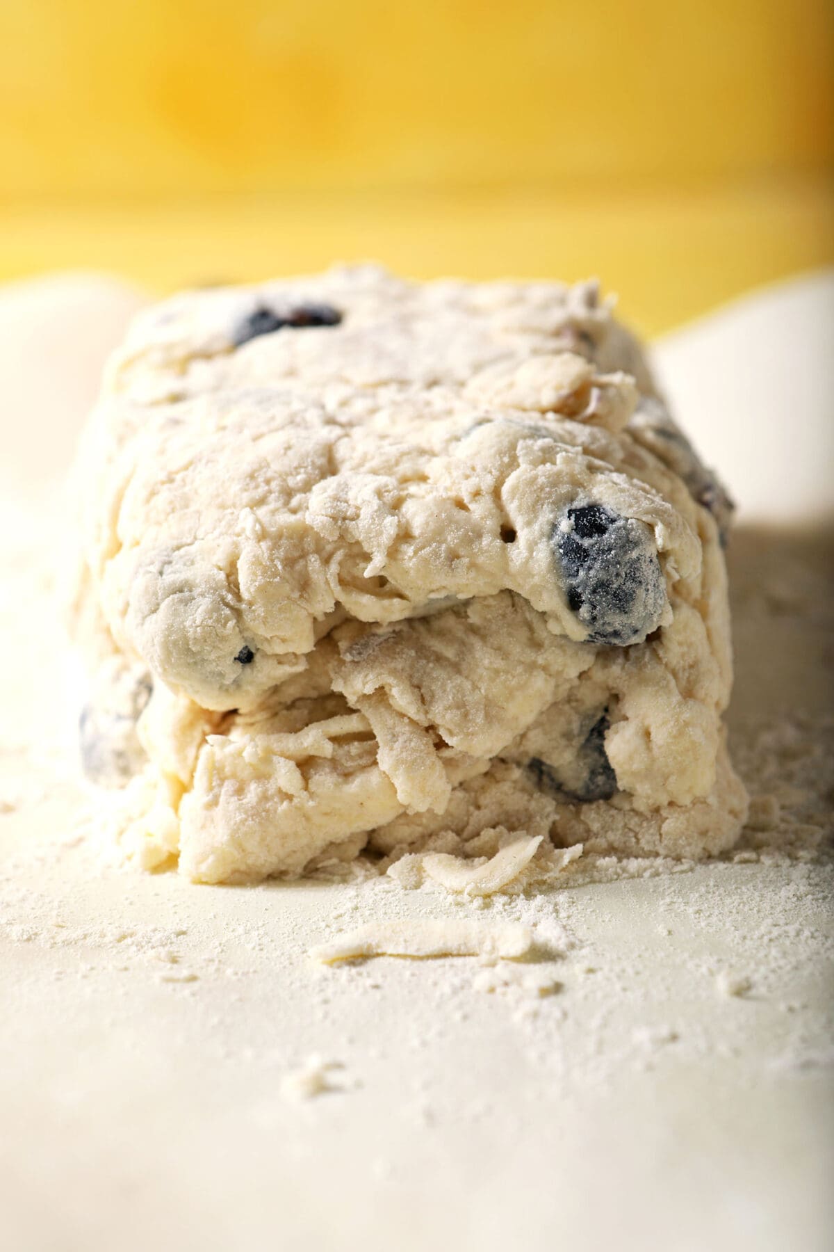 Folded biscuit dough on a floured surface