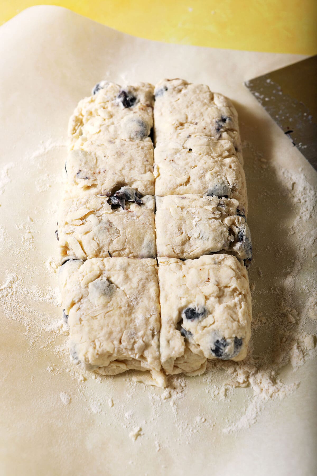 Sliced biscuit dough on parchment paper