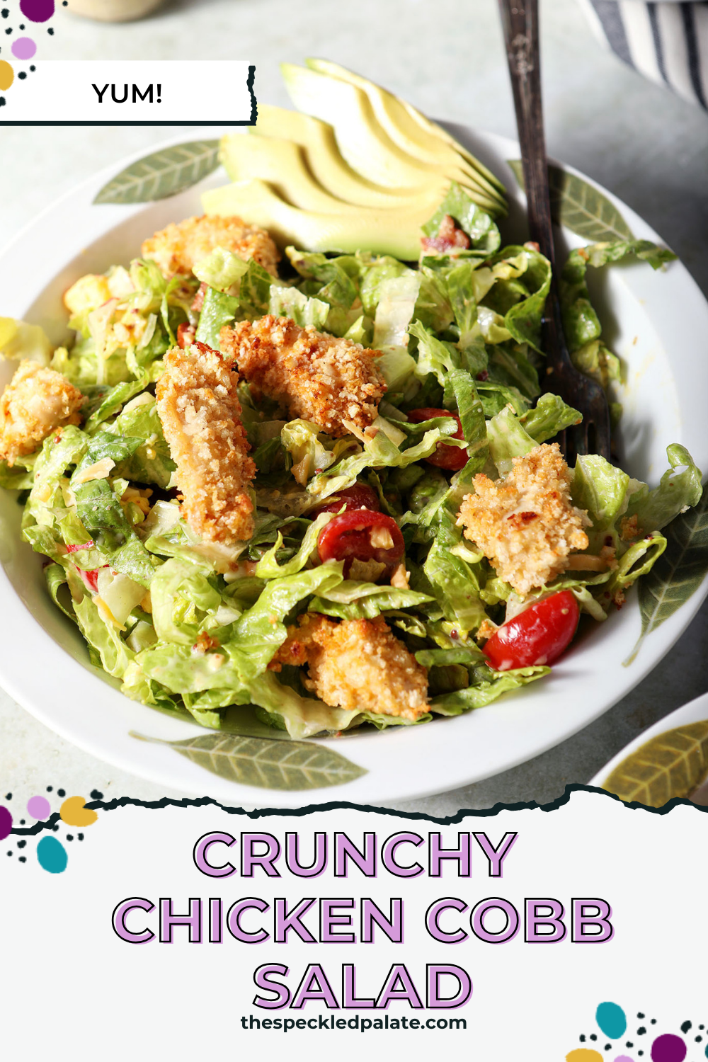 close up of a bowl of crispy chicken cobb salad with a fork in it on a green surface with the text crunchy chicken cobb salad
