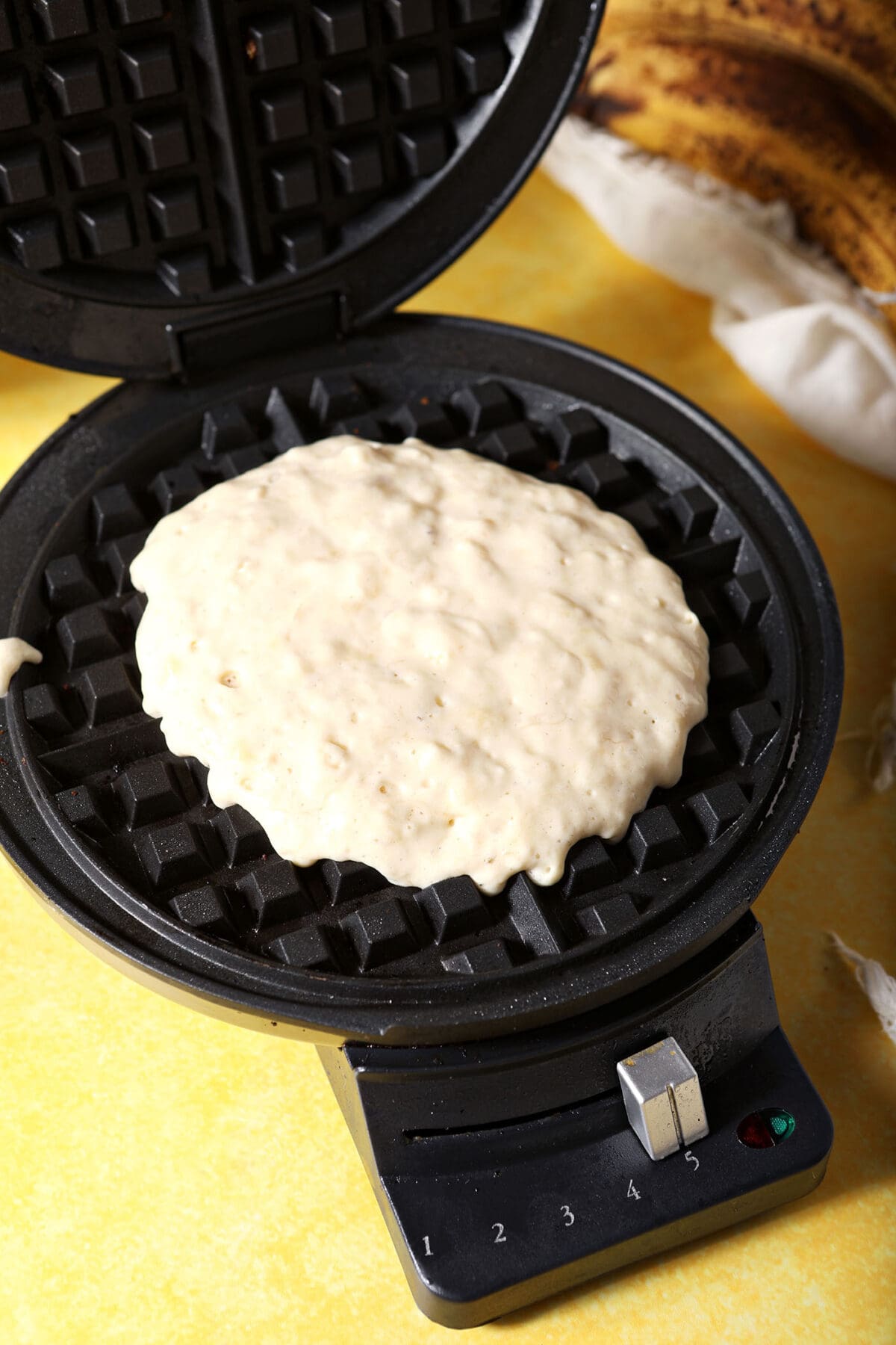 Banana waffle batter in a waffle iron, before cooking