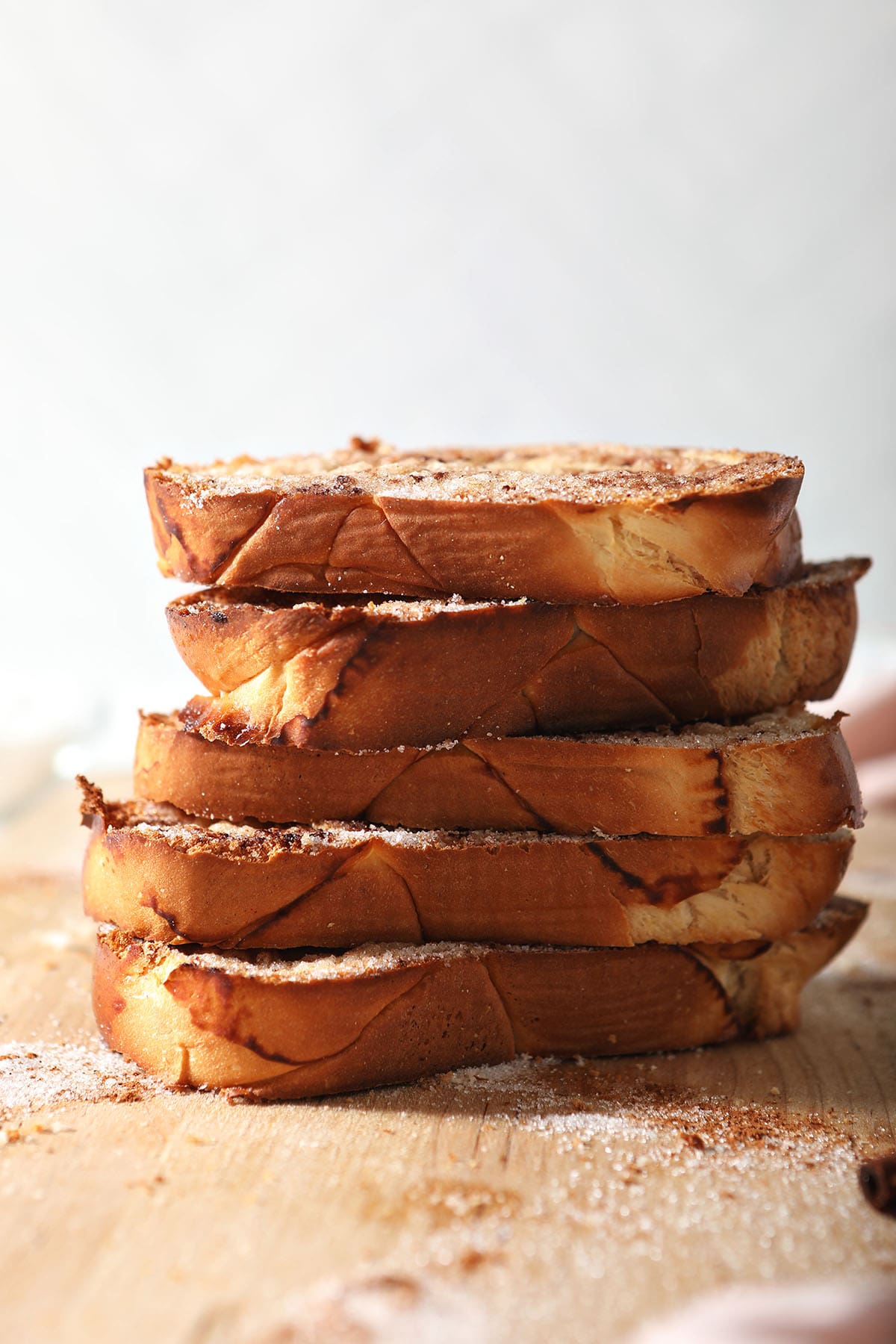 Stacked cinnamon sugar toast on a wooden cutting board