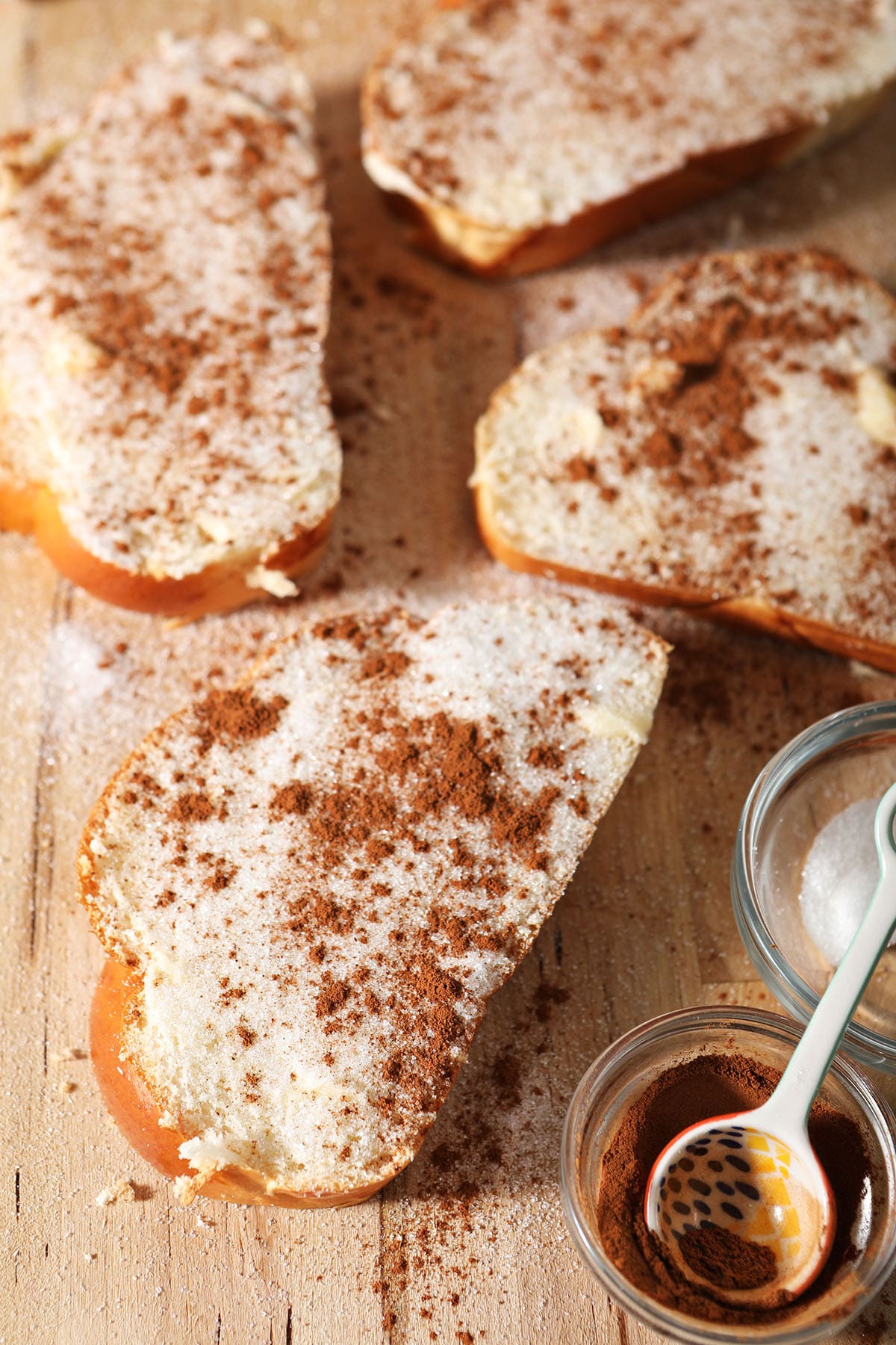 Close up of assembled cinnamon toast on a wooden board before toasting