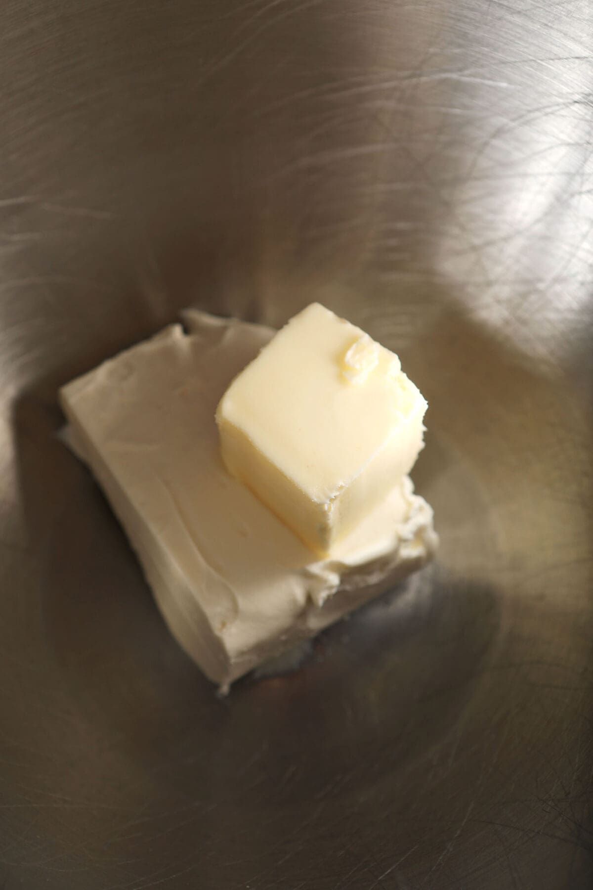 Softened butter and cream cheese in a metal bowl