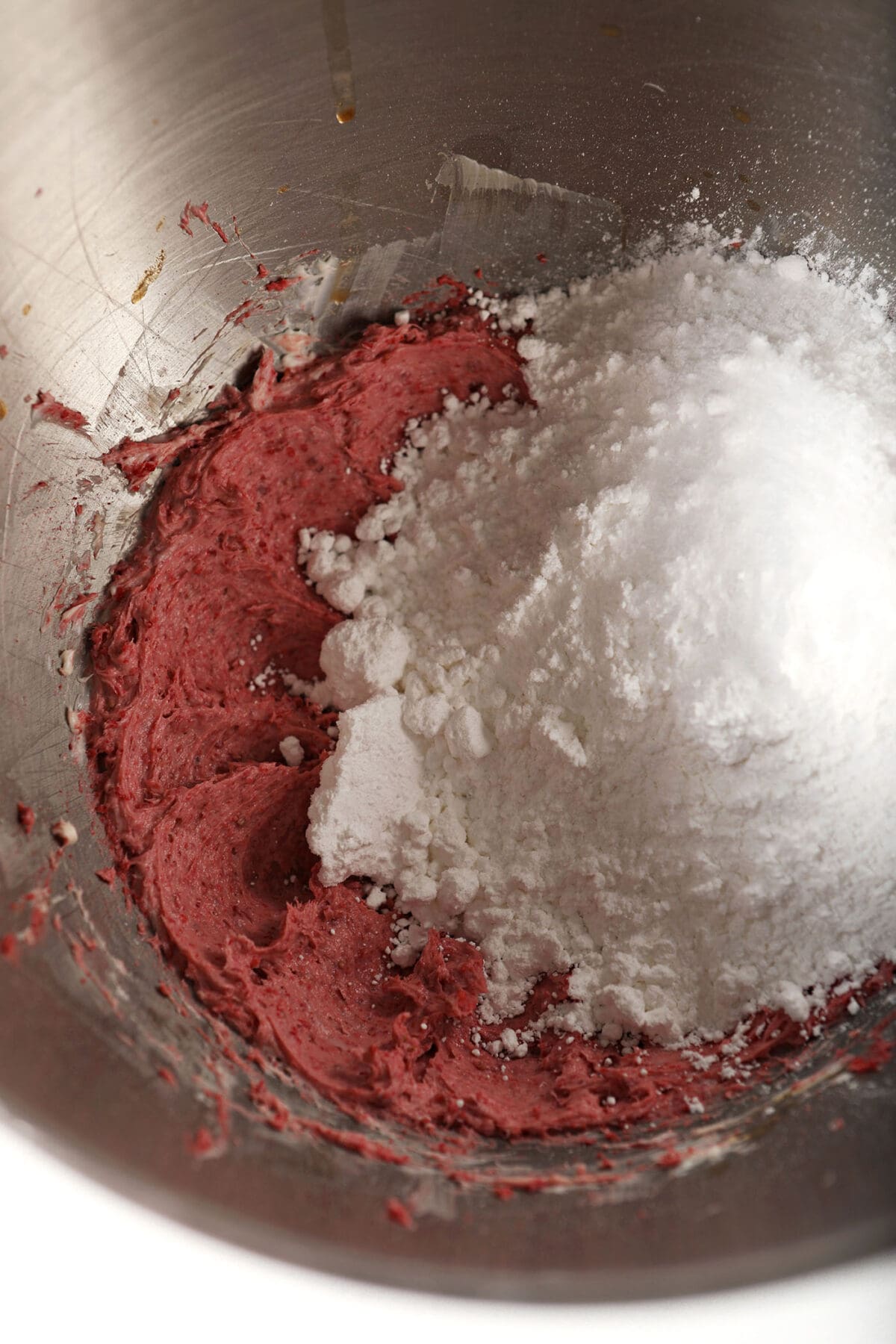 Powdered sugar on top of a strawberry mixture in a metal bowl