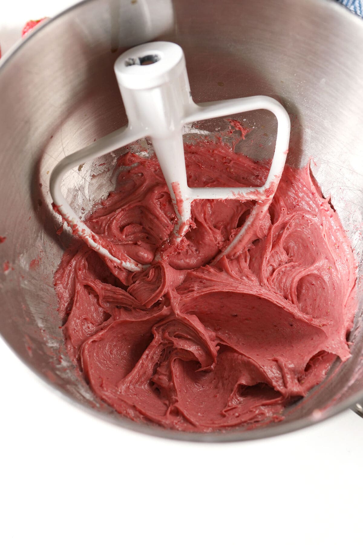 Whipped Strawberry Cream Cheese Frosting in a metal bowl with a paddle attachment
