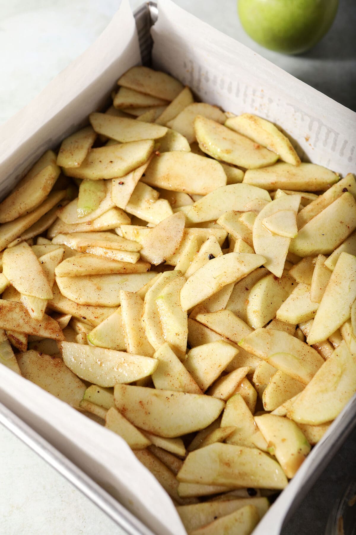 Seasoned apple slices in a baking dish
