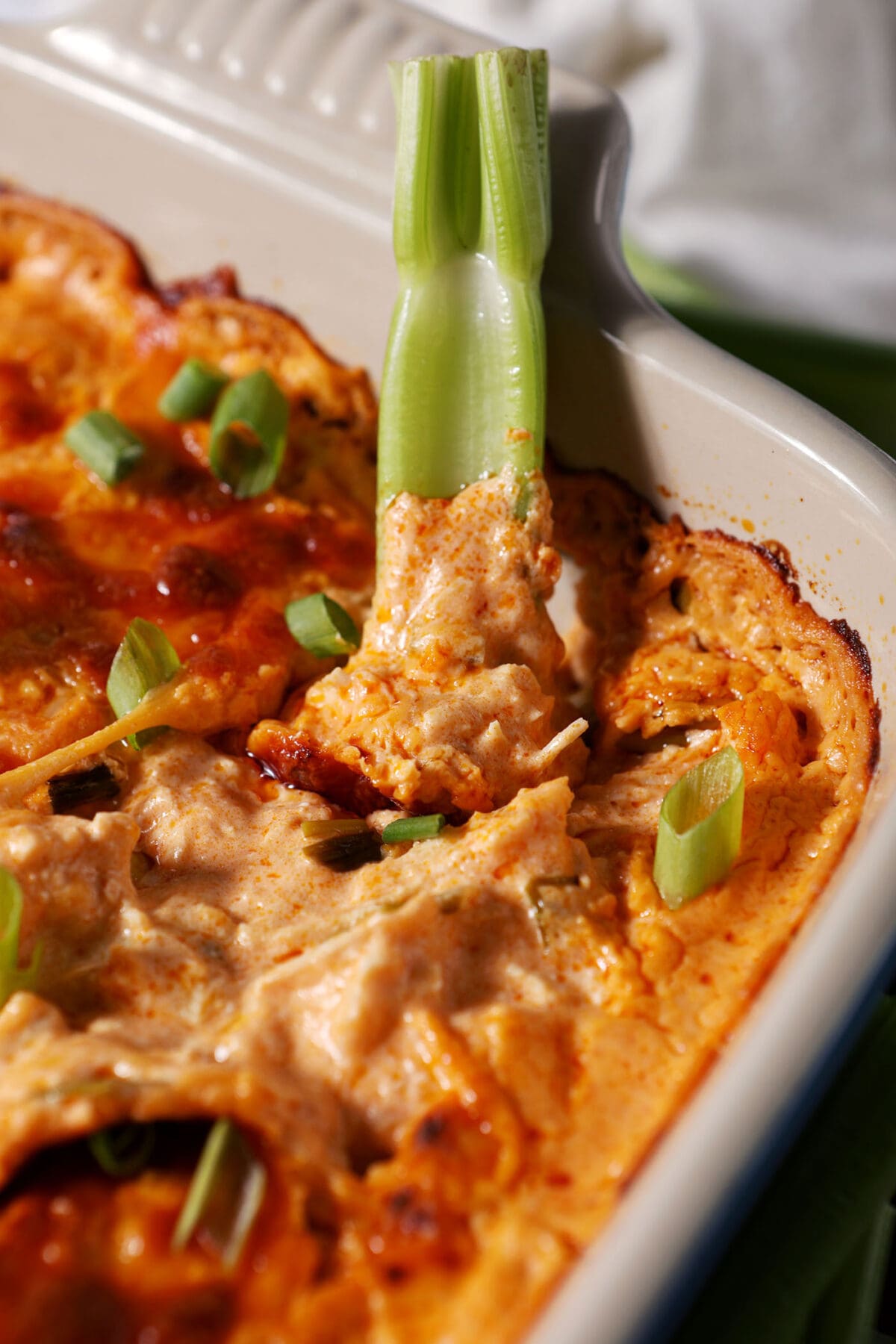 Close up of a celery rib in buffalo dip
