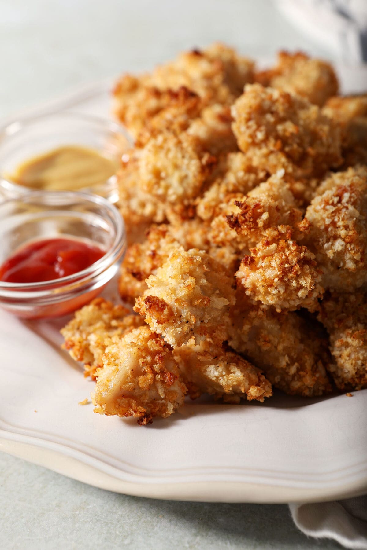 A platter holding several homemade Chicken Nuggets with dipping sauces