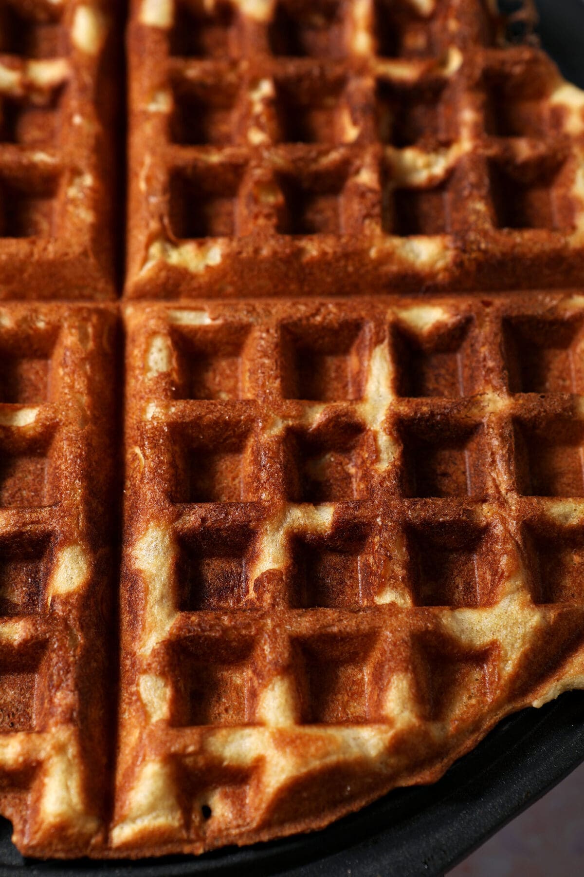 Close up of a peanut butter waffle in a waffle iron